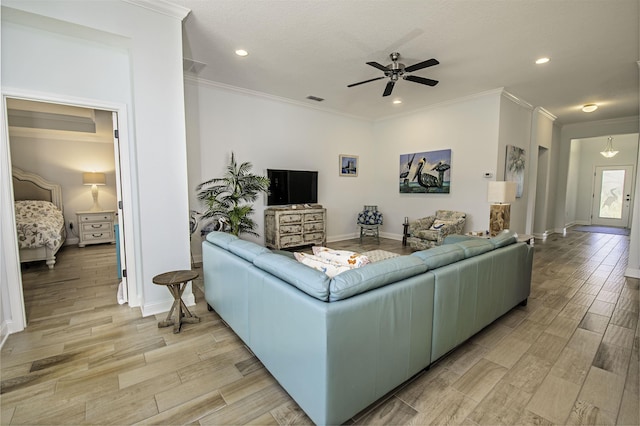 living room featuring ceiling fan, ornamental molding, and light hardwood / wood-style flooring