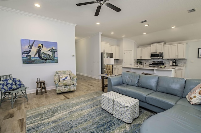 living room featuring ceiling fan, sink, light hardwood / wood-style flooring, crown molding, and lofted ceiling