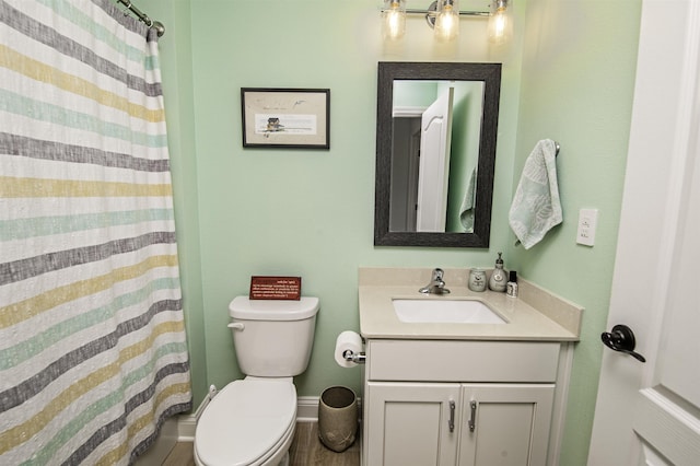 bathroom with vanity, toilet, and curtained shower