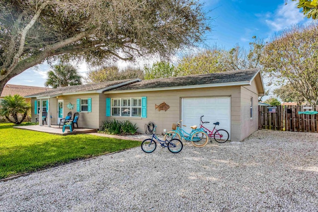 back of property featuring a yard, fence, driveway, and an attached garage