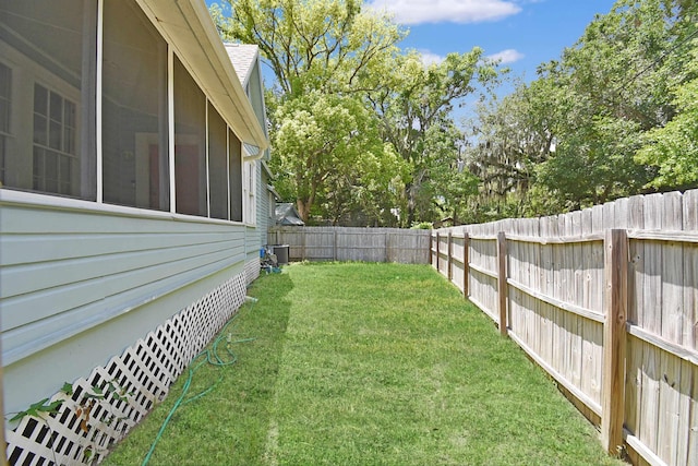 view of yard featuring central air condition unit and a sunroom