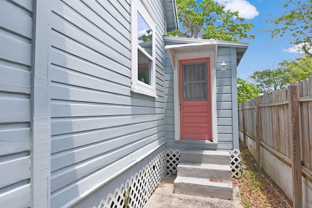 view of exterior entry featuring fence