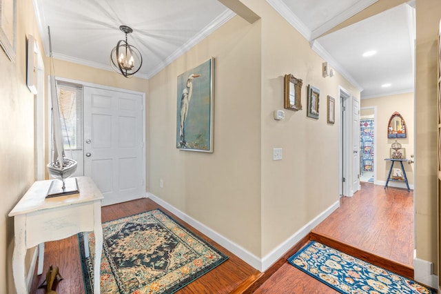 entryway featuring a notable chandelier, wood-type flooring, and crown molding