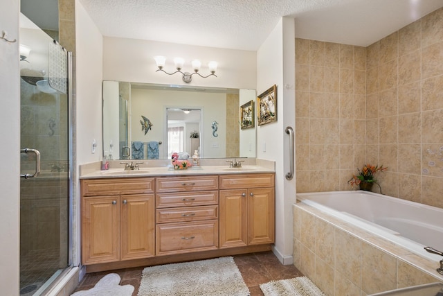 bathroom featuring tile patterned floors, vanity, plus walk in shower, and a textured ceiling