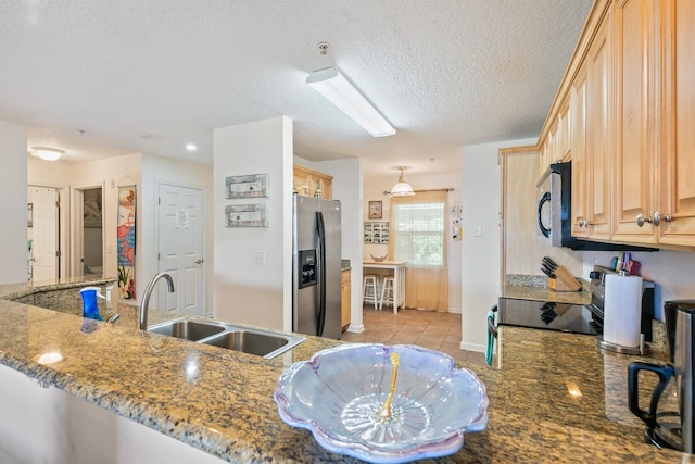 kitchen featuring light brown cabinets, sink, dark stone countertops, a textured ceiling, and stainless steel appliances