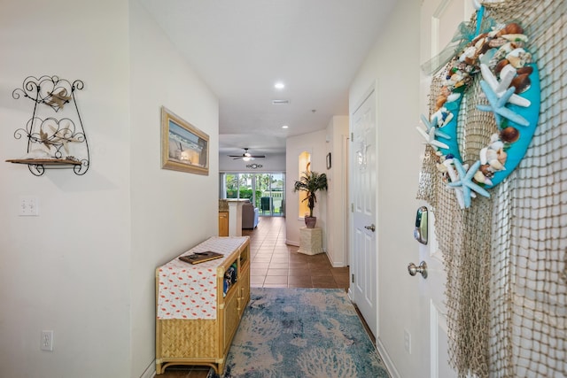 hallway featuring dark tile patterned floors