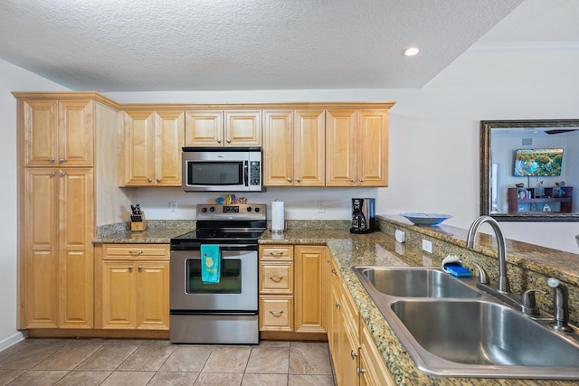 kitchen featuring stone counters, sink, a textured ceiling, light tile patterned floors, and appliances with stainless steel finishes