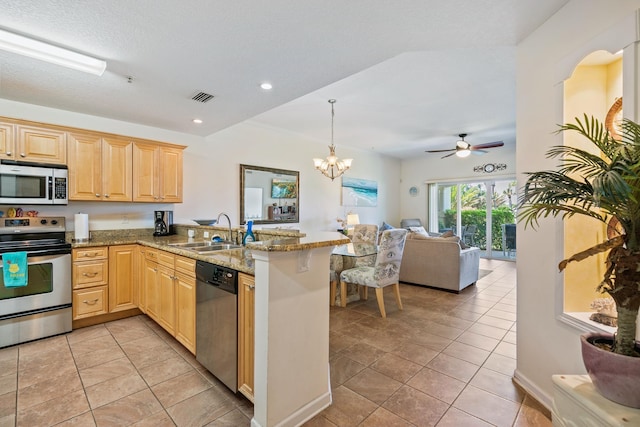 kitchen featuring kitchen peninsula, light brown cabinetry, stainless steel appliances, and sink