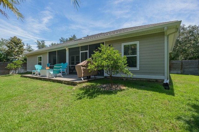 back of house featuring a patio area, a sunroom, and a yard