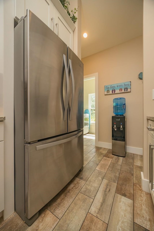 kitchen featuring white cabinetry and stainless steel refrigerator