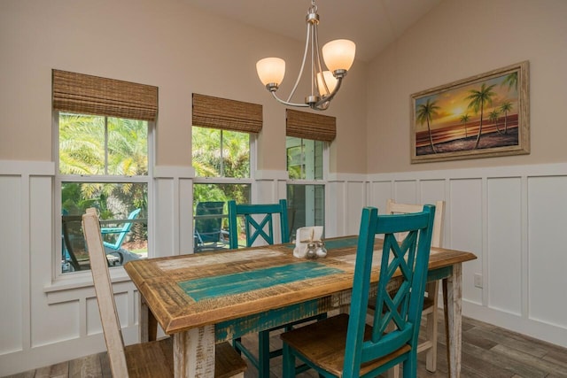 dining room with dark wood-type flooring, lofted ceiling, and an inviting chandelier