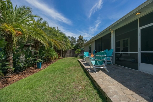 view of yard featuring a sunroom and a patio