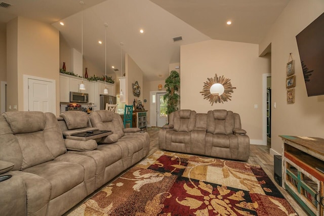 living room with high vaulted ceiling and hardwood / wood-style flooring