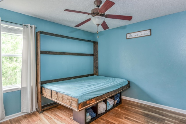 104 Claremont Ct, Elkton, FL 32033 - bedroom featuring multiple windows, a textured ceiling, a ceiling fan, and wood finished floors