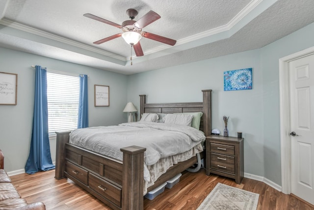 104 Claremont Ct, Elkton, FL 32033 - bedroom with ornamental molding, a textured ceiling, a raised ceiling, light wood-type flooring, and a ceiling fan
