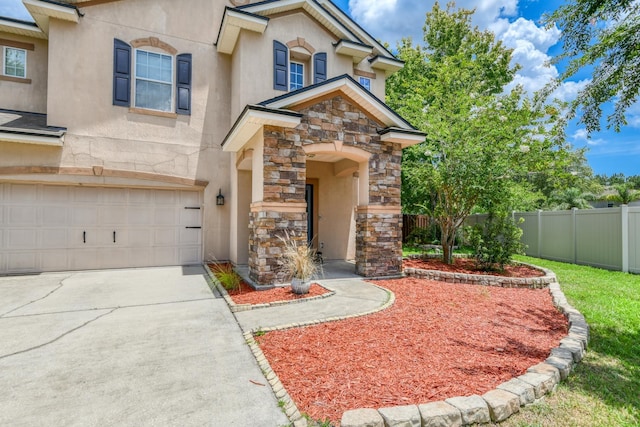 104 Claremont Ct, Elkton, FL 32033 - view of front of house with stone siding, an attached garage, stucco siding, and concrete driveway