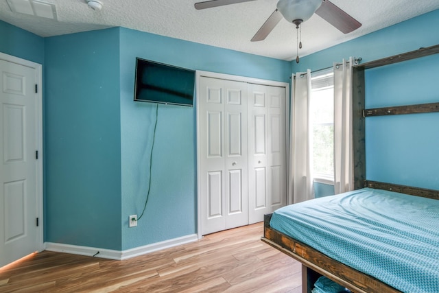104 Claremont Ct, Elkton, FL 32033 - bedroom with wood finished floors, a ceiling fan, a closet, and a textured ceiling