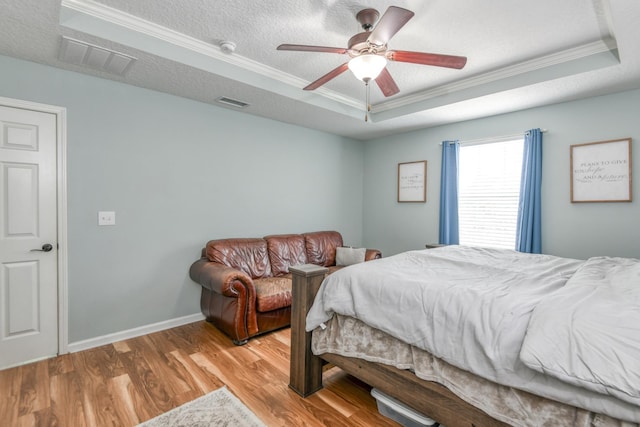 104 Claremont Ct, Elkton, FL 32033 - bedroom featuring a tray ceiling, ornamental molding, wood finished floors, a ceiling fan, and a textured ceiling