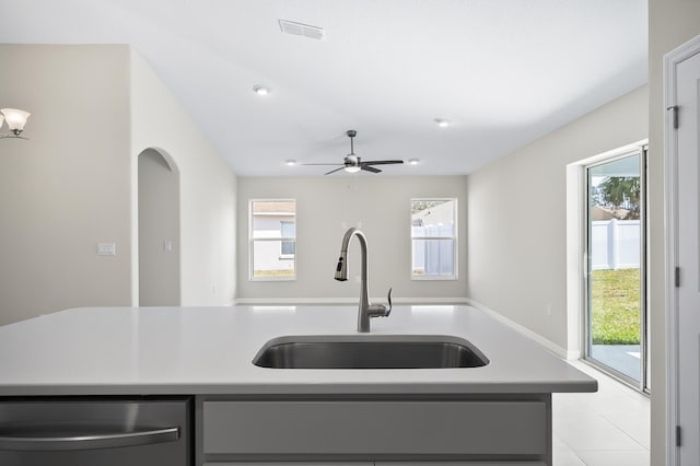 kitchen featuring a kitchen island with sink, sink, stainless steel dishwasher, and ceiling fan