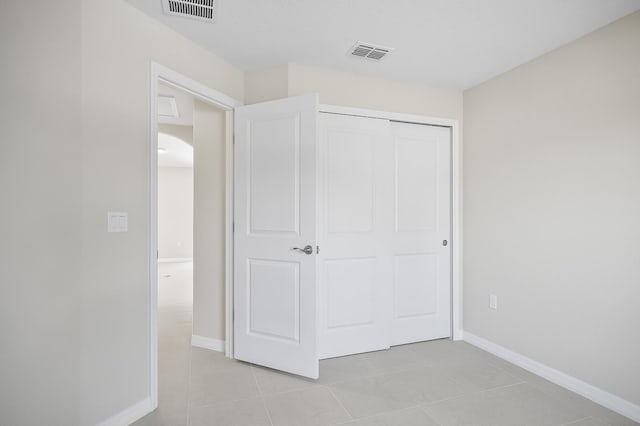 unfurnished bedroom with light tile patterned flooring and a closet