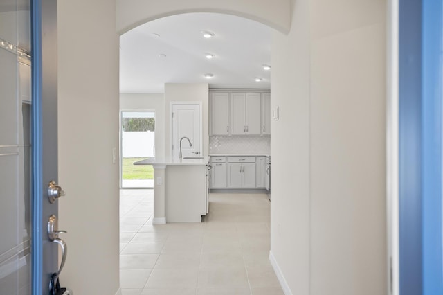 corridor featuring sink and light tile patterned floors