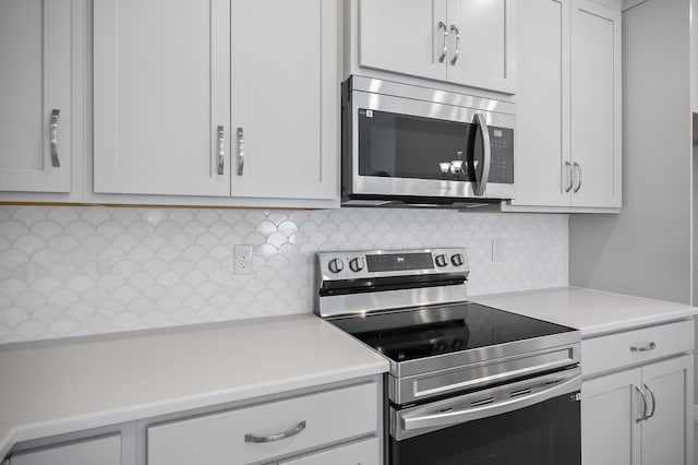 kitchen with appliances with stainless steel finishes, decorative backsplash, and white cabinets