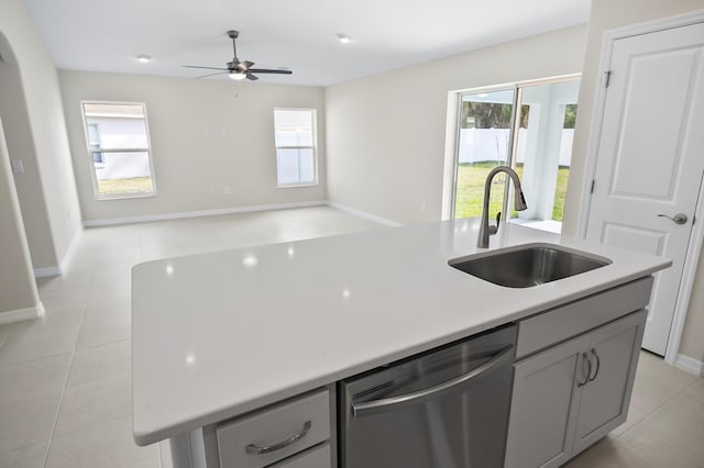 kitchen with sink, dishwasher, gray cabinetry, a healthy amount of sunlight, and a center island with sink