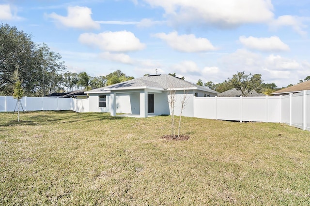 rear view of property featuring a yard