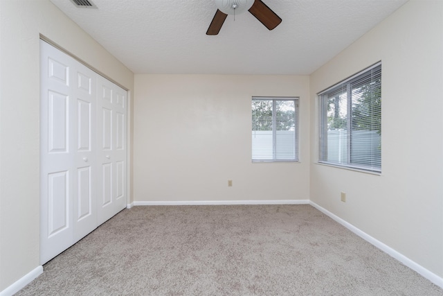 unfurnished bedroom featuring light carpet, a closet, and ceiling fan