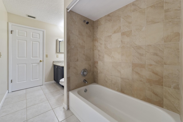 bathroom featuring tile patterned floors, vanity, a textured ceiling, and tiled shower / bath combo