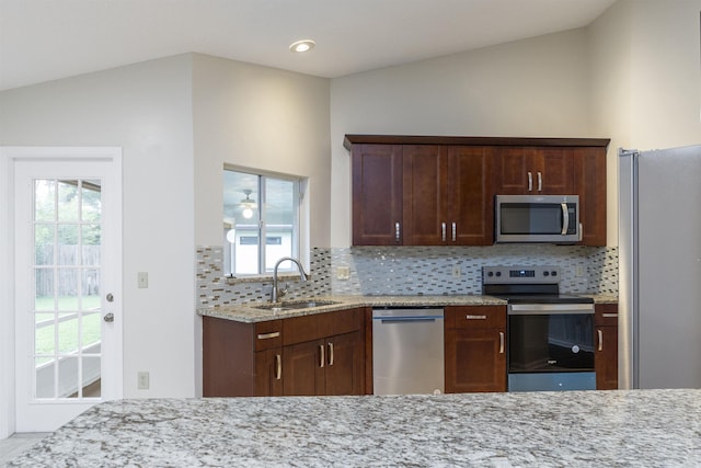 kitchen with backsplash, sink, lofted ceiling, and stainless steel appliances