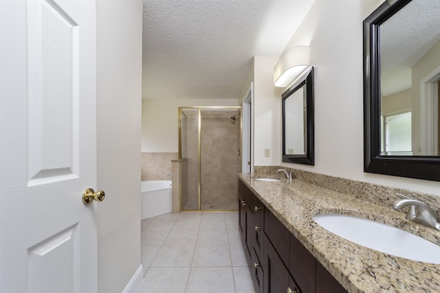 bathroom with tile patterned flooring, vanity, a textured ceiling, and shower with separate bathtub