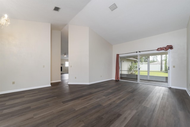 empty room with dark wood-type flooring and high vaulted ceiling