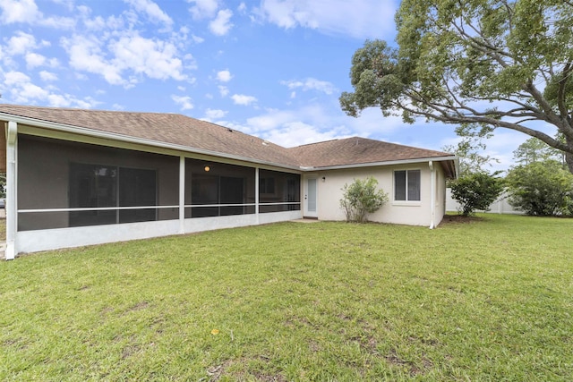 rear view of property with a yard and a sunroom