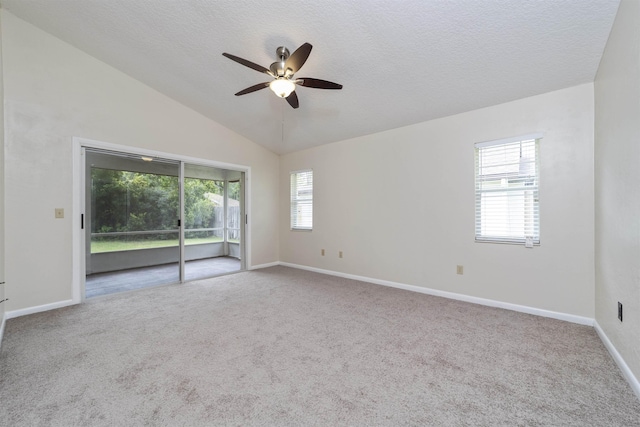 carpeted spare room featuring ceiling fan, lofted ceiling, and a textured ceiling