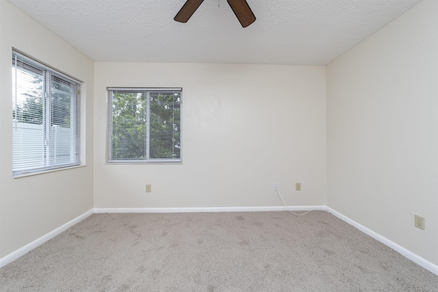 carpeted spare room featuring ceiling fan and a textured ceiling