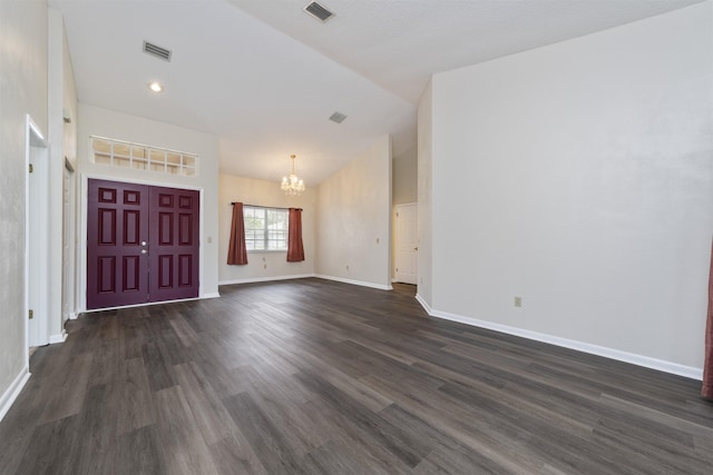 entryway with dark hardwood / wood-style flooring, lofted ceiling, and an inviting chandelier