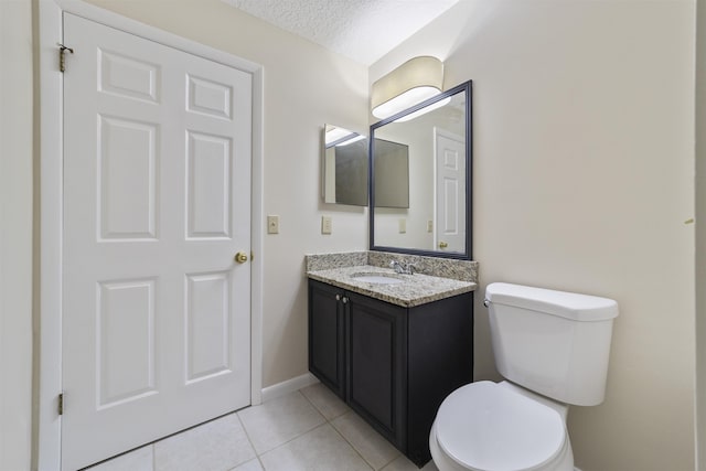 bathroom with tile patterned flooring, vanity, toilet, and a textured ceiling