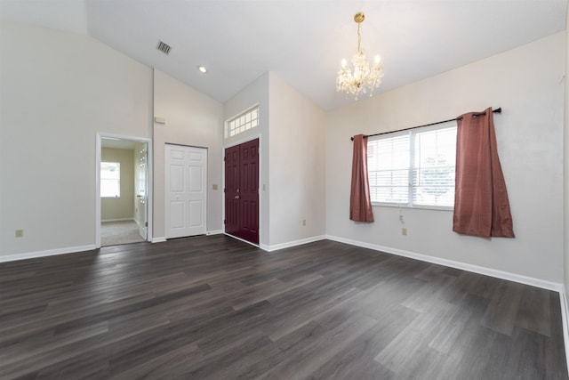 foyer featuring dark wood-type flooring, high vaulted ceiling, and a notable chandelier