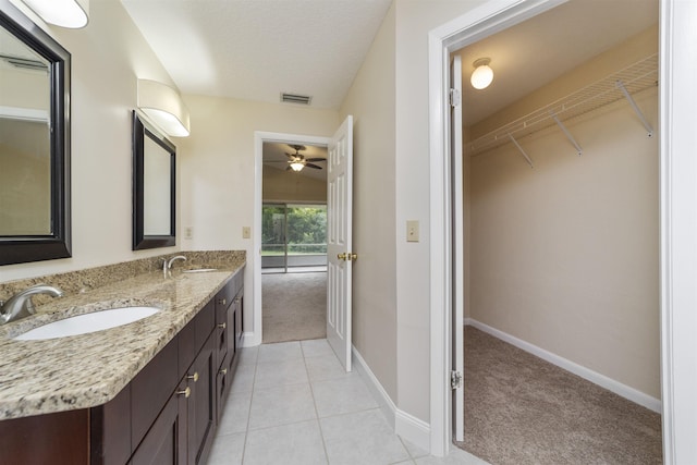 bathroom with tile patterned flooring, vanity, and ceiling fan