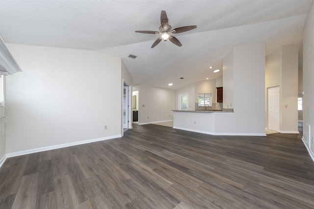 unfurnished living room with a textured ceiling, dark hardwood / wood-style floors, vaulted ceiling, and ceiling fan