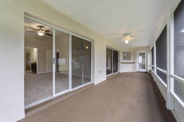 unfurnished sunroom featuring ceiling fan