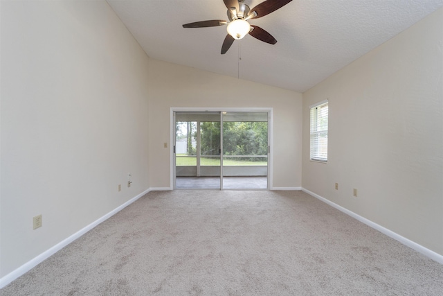 carpeted empty room with ceiling fan, a textured ceiling, and vaulted ceiling