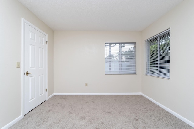 carpeted spare room featuring a textured ceiling