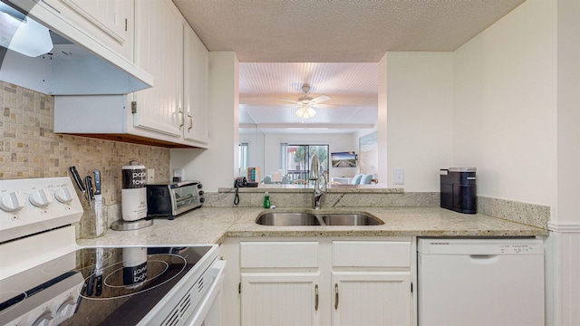 kitchen featuring white appliances, backsplash, sink, ceiling fan, and white cabinetry