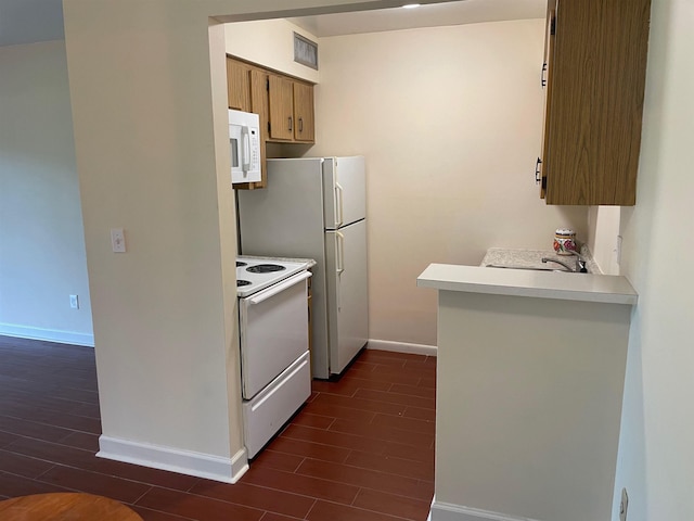 kitchen featuring dark hardwood / wood-style flooring, white appliances, and sink