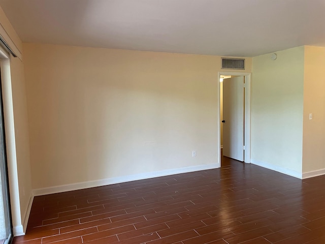 unfurnished room with dark wood-type flooring