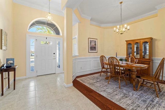 tiled entryway with crown molding and a chandelier