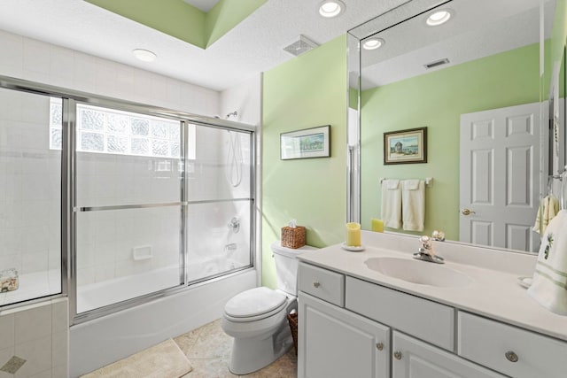 full bathroom with toilet, combined bath / shower with glass door, a textured ceiling, vanity, and tile patterned flooring