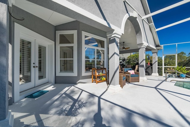 view of patio / terrace with a pool, a lanai, ceiling fan, and french doors